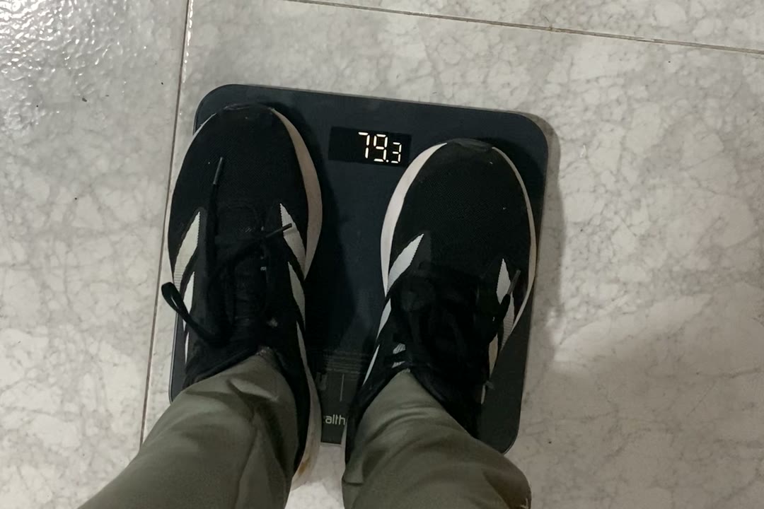 Los pies de Alejandro Arias sobre la báscula