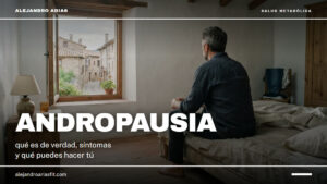Andropausia: hombre de espaldas sentado en el borde de la cama mirando por la ventana por la mañana