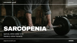 Sarcopenia: manos de un hombre mayor agarrando una barra cargada en el suelo del gimnasio